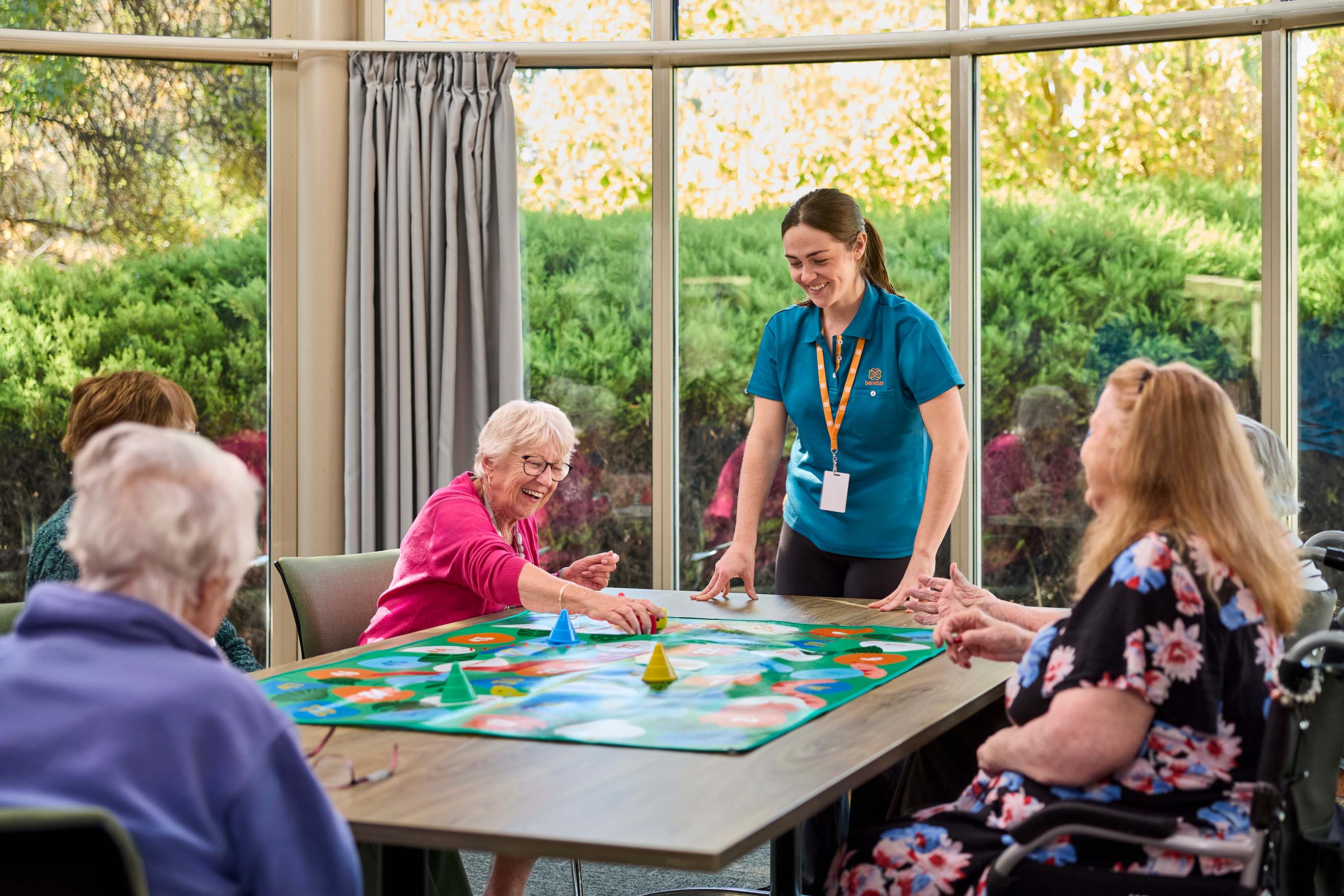 Residents and Benetas team member enjoying a group activity in the activities room at Benetas Kangaroo Flat