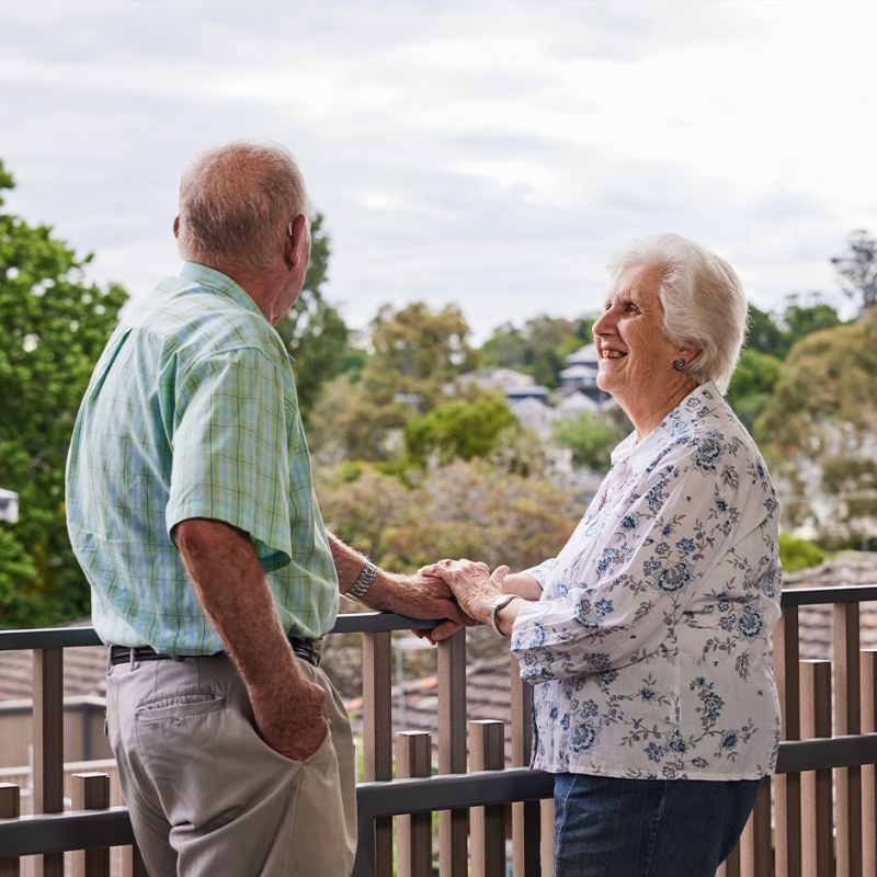 An older Australian couple enjoying the view from a balcony, cherishing their time together.