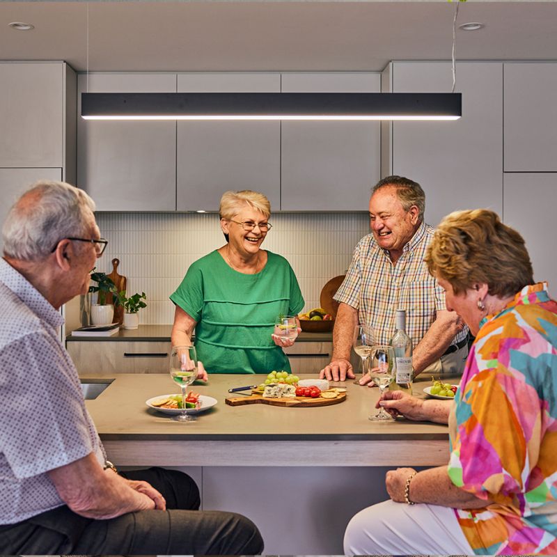 A diverse group of individuals enjoying a meal together at a table, sharing food and engaging in conversation.